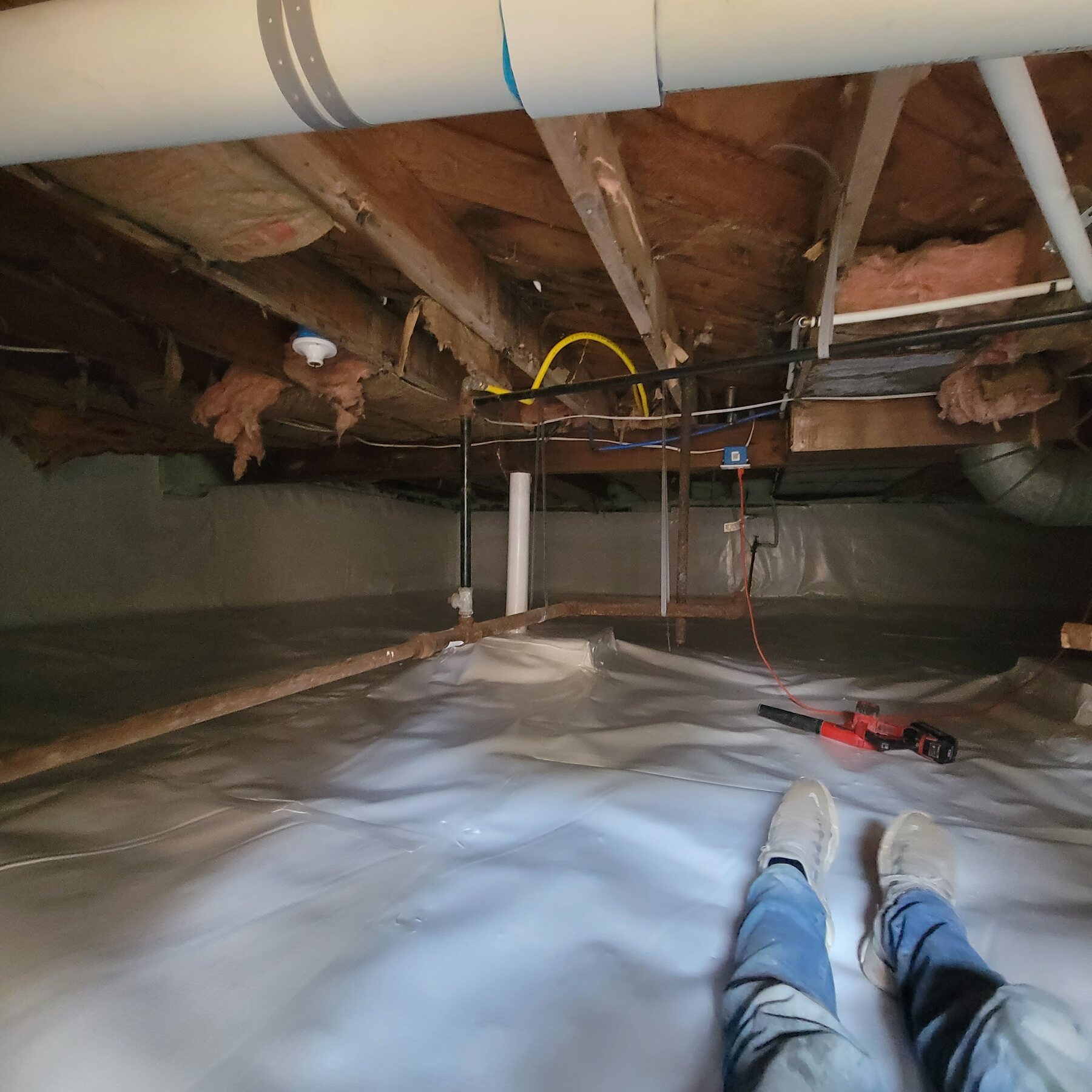 Installed white vapor barrier inside a residential crawl space